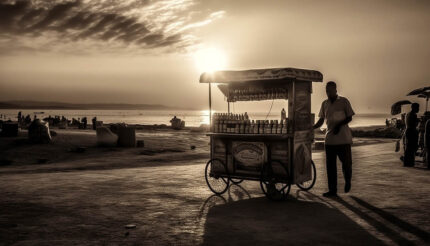 Günbatımında deniz kıyısında yemek arabalı adam